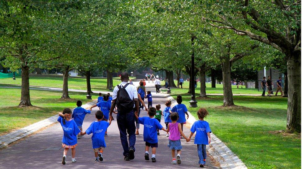 A daycare class walking in a public park in Boston