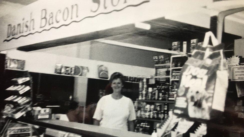 Woman behind a delicatessen counter