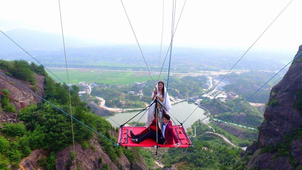 The couple suspended off Shiniuzhai glass bridge, 9 August 2016