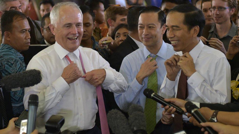 Australia's Prime Minister Malcolm Turnbull (L) and Indonesian President Joko Widodo (R) loosen their ties as they visit the Tanah Abang retail market in Jakarta on November 12, 2015. Turnbull made his first visit to Indonesia since taking power, seeking to repair a key relationship strained by repeated crises under his conservative predecessor.