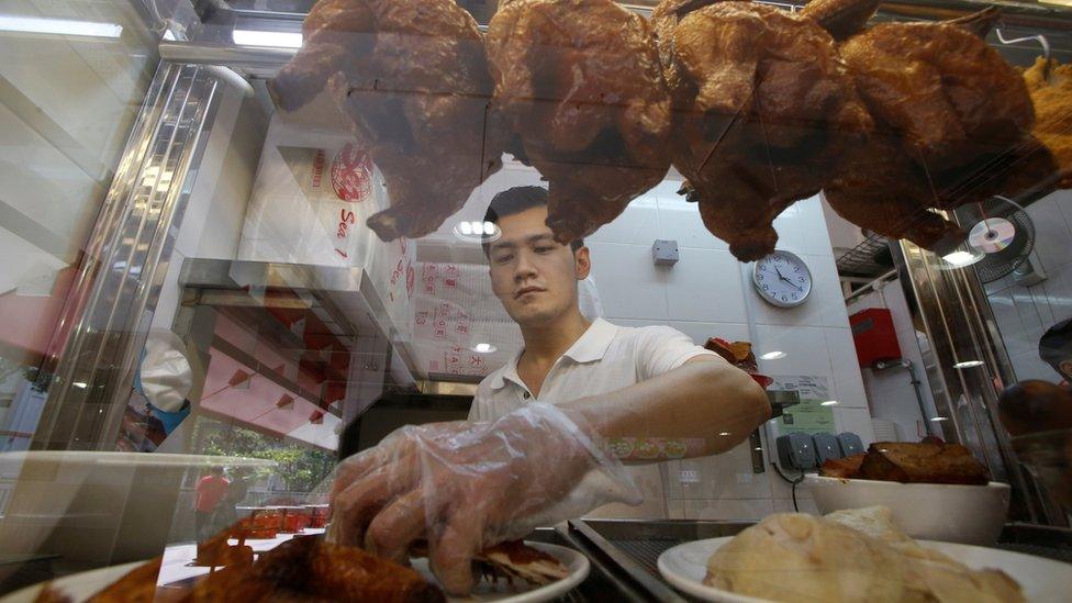 A hawker sells chicken rice at his stall