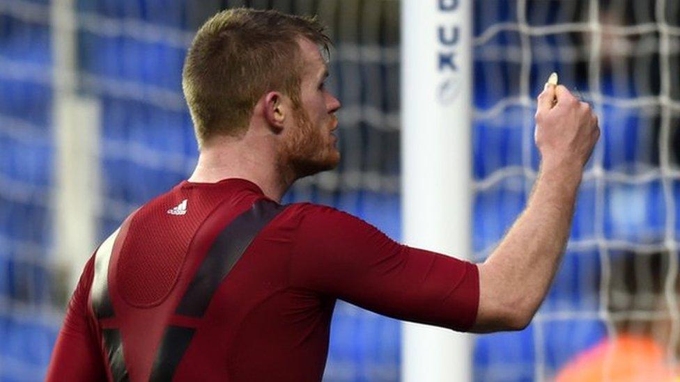 Chris Brunt holds up object