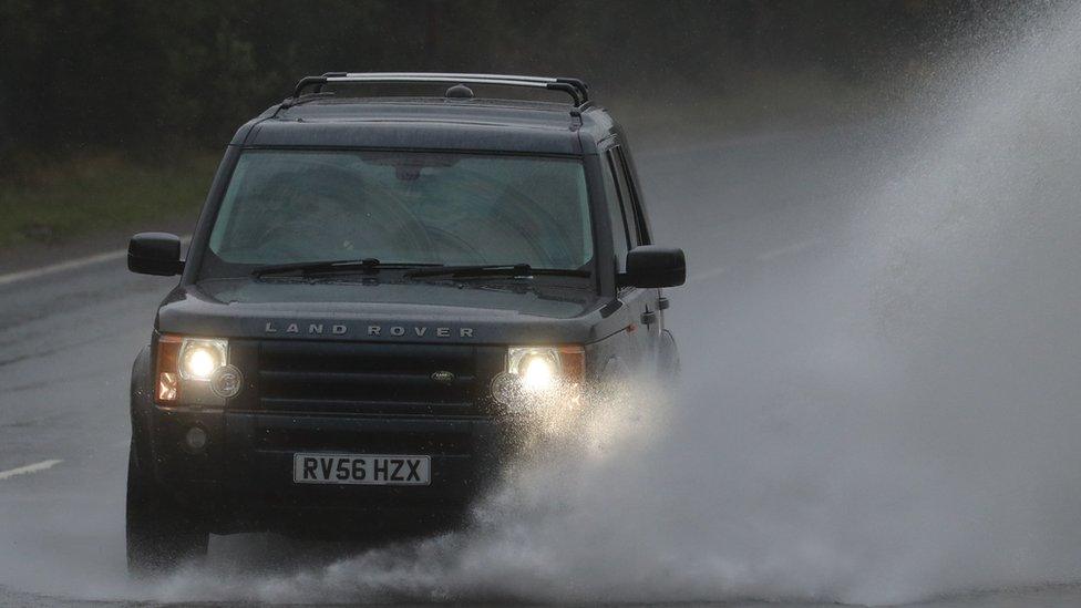 A car drives through a large puddle on the A20 in Folkestone, Kent