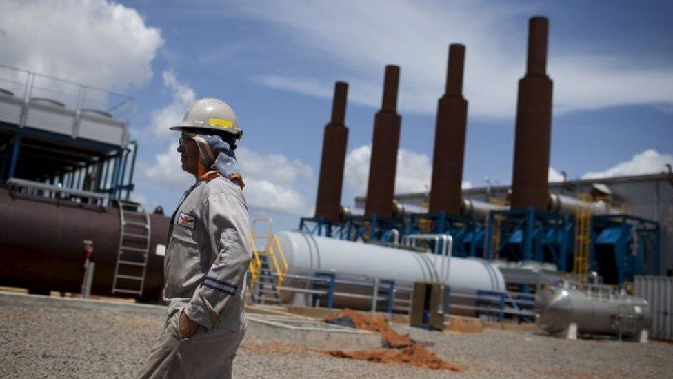 An oil worker walks past an oil installation operated by Venezuela's state oil company PDVSA in Morichal (July 2011)