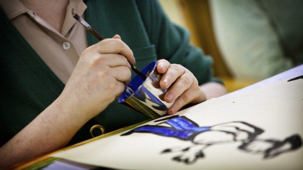 An elderly person painting