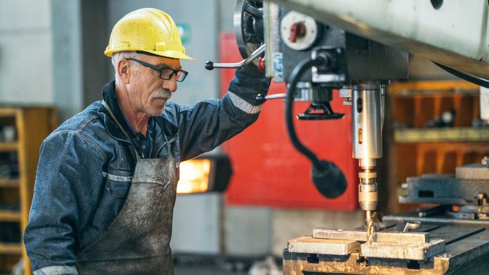 Older man working on a drill bit.