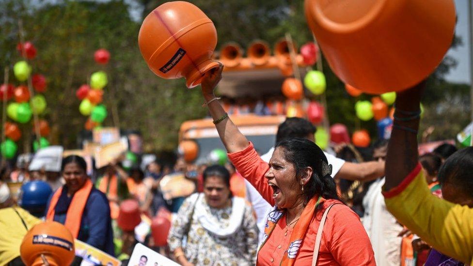 Activists and members of the Bharatiya Janata Party (BJP) hold empty water pots as they shout slogans during a protest against the state government over ongoing severe water crisis, in Bengaluru on March 12, 2024.