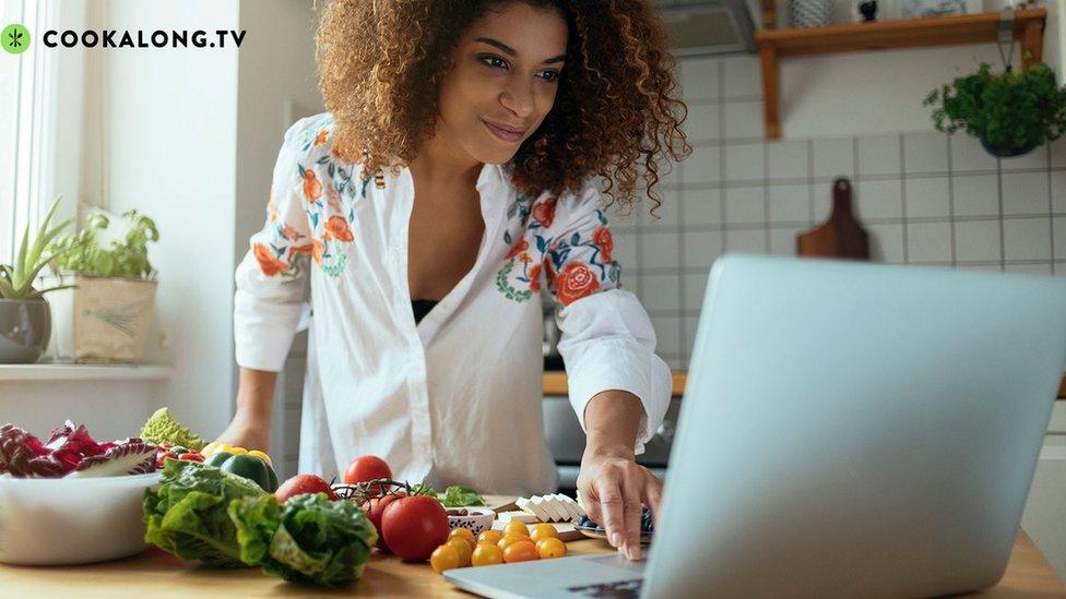 Woman cooking with laptop