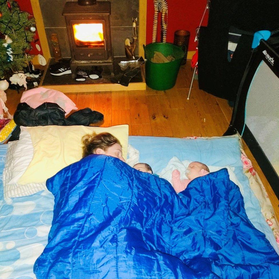 Siobhan Bradley and twins in front of wood burner