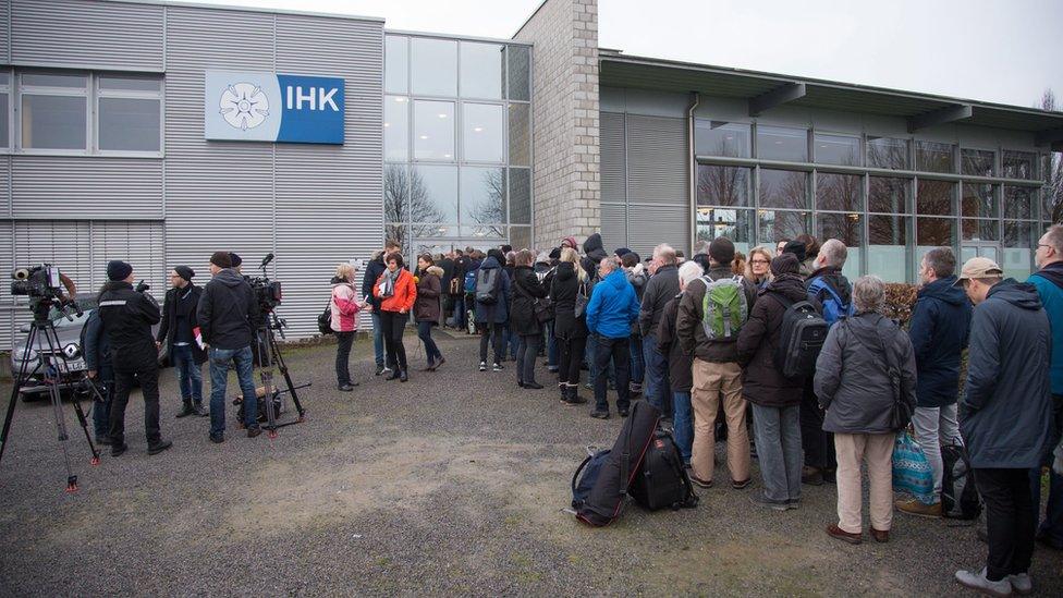 People stand outside the Chamber of Commerce in Detmold, Germany, 11 February 2016