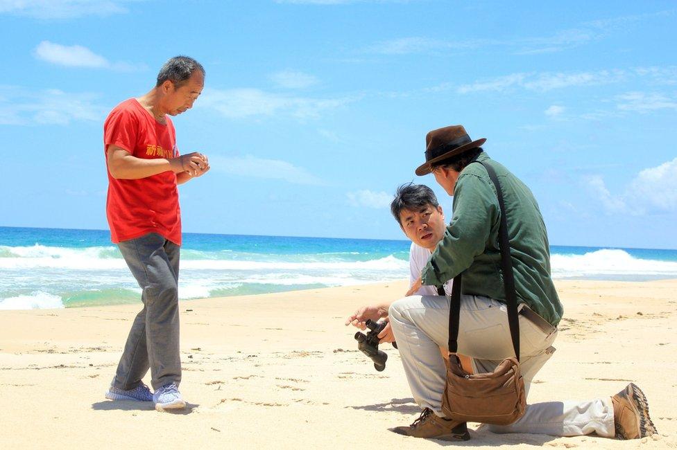 Blaine Gibson, an American lawyer turned self-funded sleuth (R) and relatives of some passengers from a Malaysia Airlines Flight MH370, carrying 239 passengers and crew, that went missing more than two years ago are seen at the beach at the Sainte Marie island in the Analanjirofo Region of Madagascar, 7 December 2016