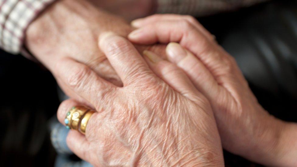 A dementia patient being comforted by a relative