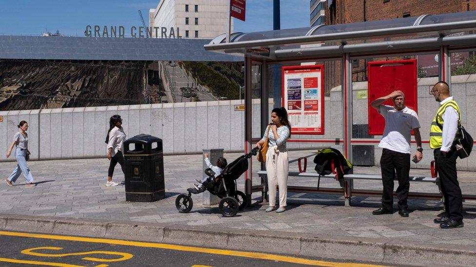 People at a bus stop in Birmingham