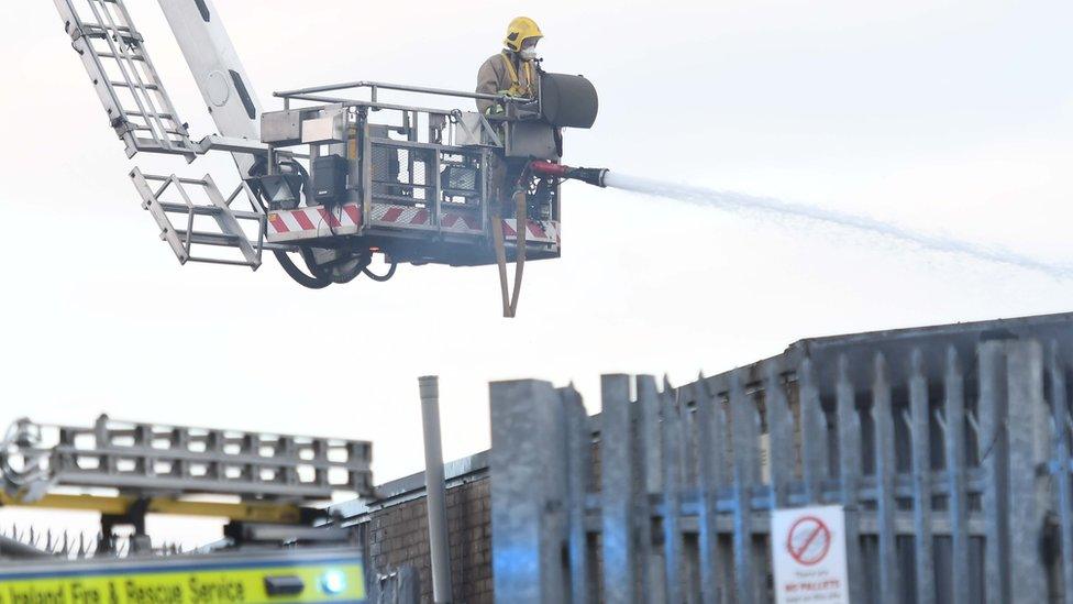 A firefighter tackles douses the flames from an aerial unit