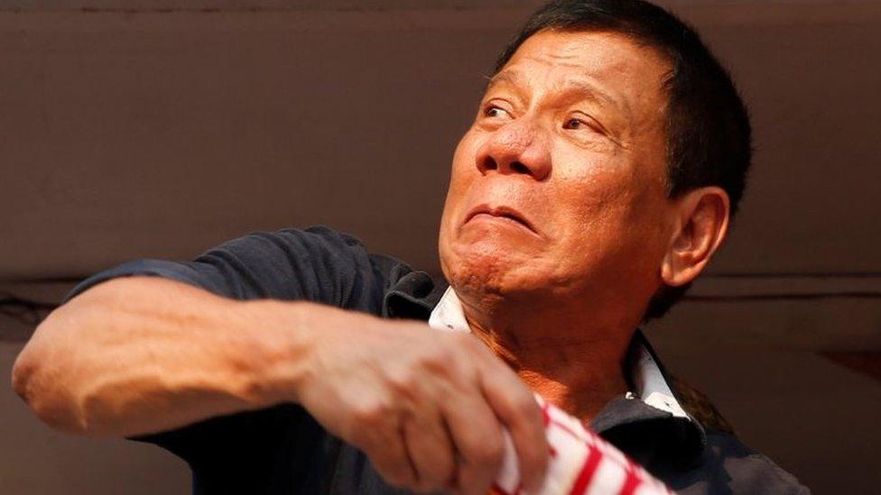 Presidential candidate Rodrigo "Digong" Duterte throws election souvenir shirts to his supporters during election campaigning in Malabon, Metro Manila