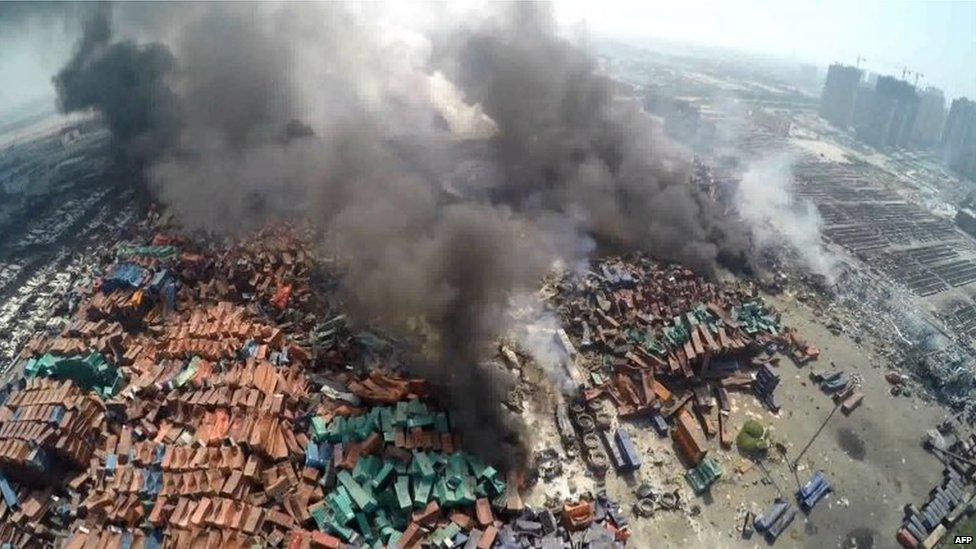 This screen grab taken from AFPTV shows an aerial image taken on August 13, 2015 of smoke rising from debris the day after a series of explosions hit a chemical warehouse in the city of Tianjin, in northern China