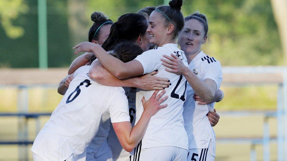 Northern Ireland Women's team hugging each other and celebrating.