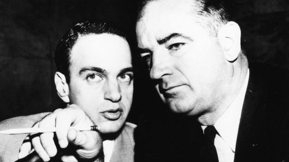 Senator Joseph McCarthy and attorney Ray Cohn in 1954 lean heads together