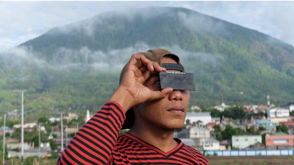 A man watches the total solar eclipse in the city of Ternate, in Indonesia's Maluku Islands