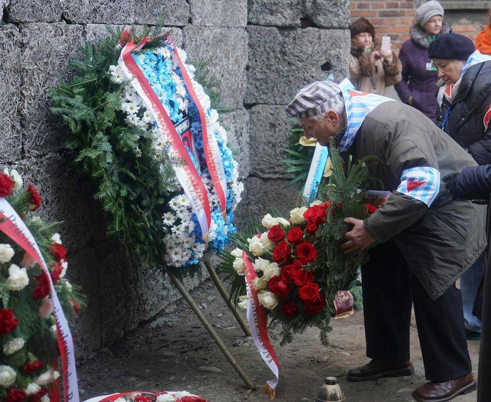 Survivors and other guests attend a wreath-laying ceremony