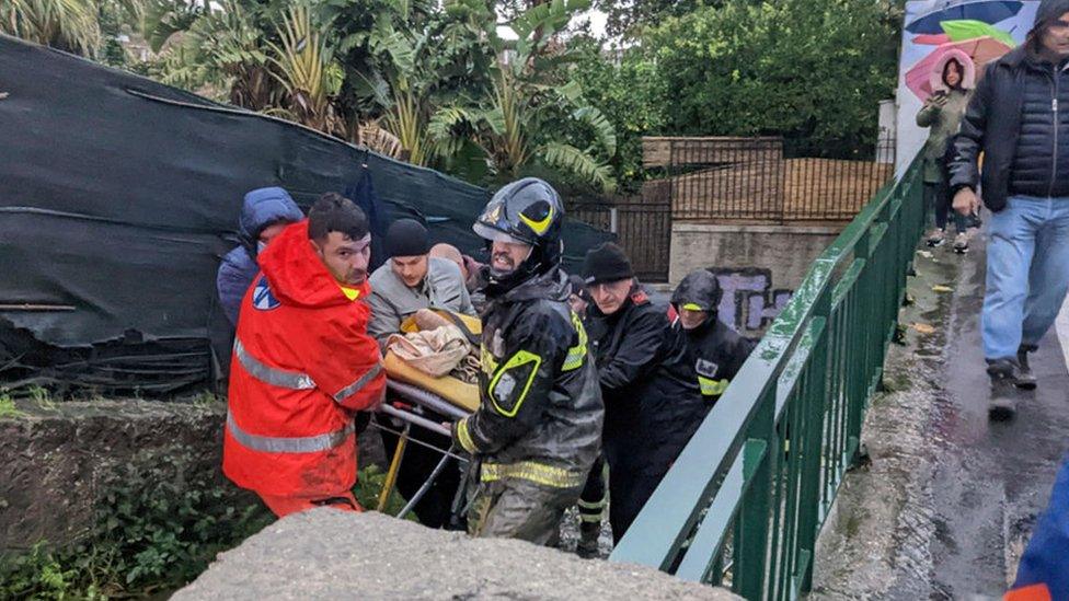 Rescuers help an injured man following the landslide