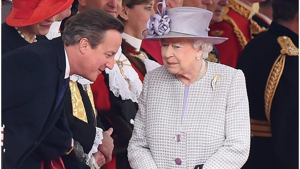 Prime Minister, David Cameron leans over to speak to Queen Elizabeth II