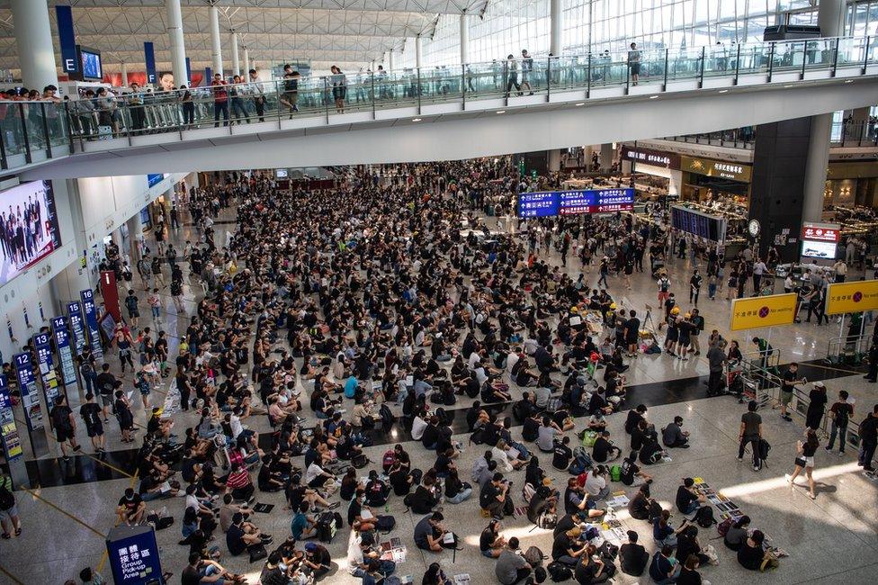 Protesters attend a sit-in against police violence in Hong Kong Chek Lap Kok International Airport