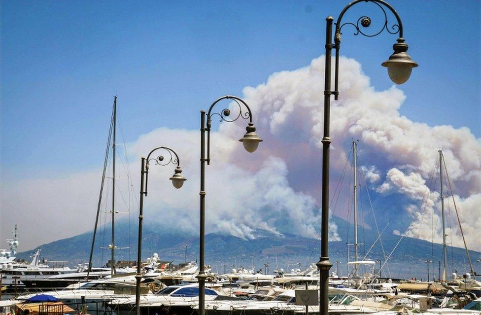 A general view over the city as smoke billows from fires around Mount Vesuvius volcano in Naples, Italy, 11 July 2017.