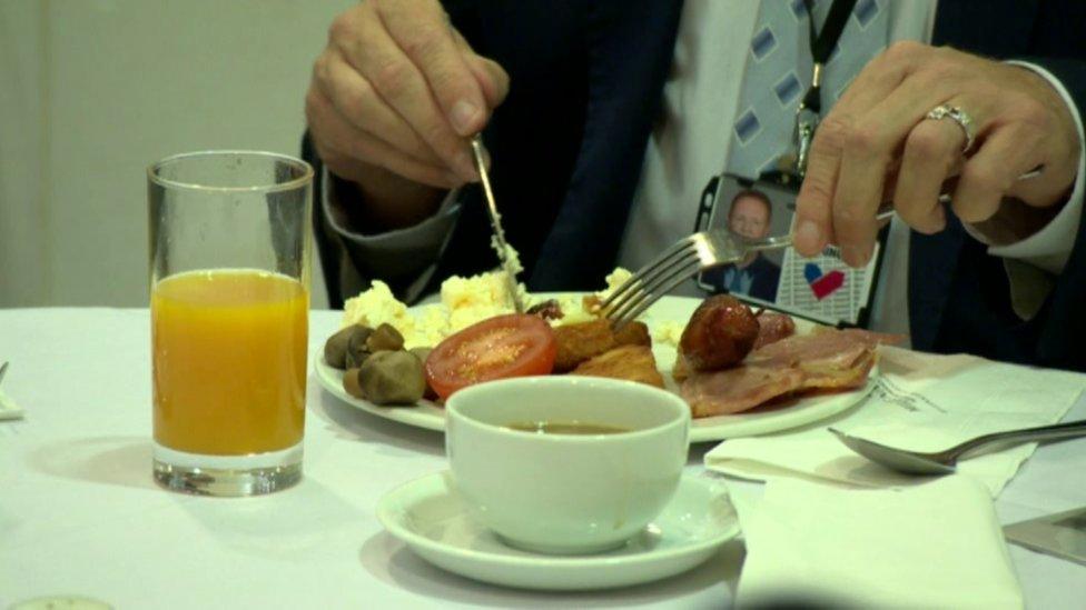 Man in suit eats fried breakfast