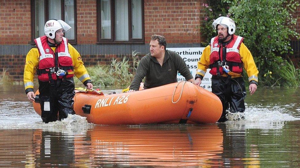 A resident is taken to safety aboard a dinghy