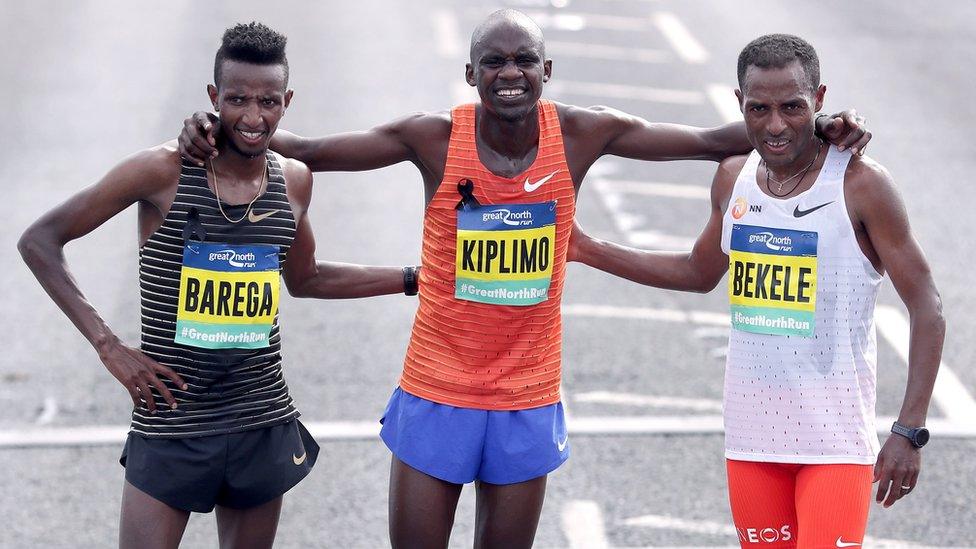 Male race runners Barega, Kiplimo and Bekele pose for a picture together after finishing the run