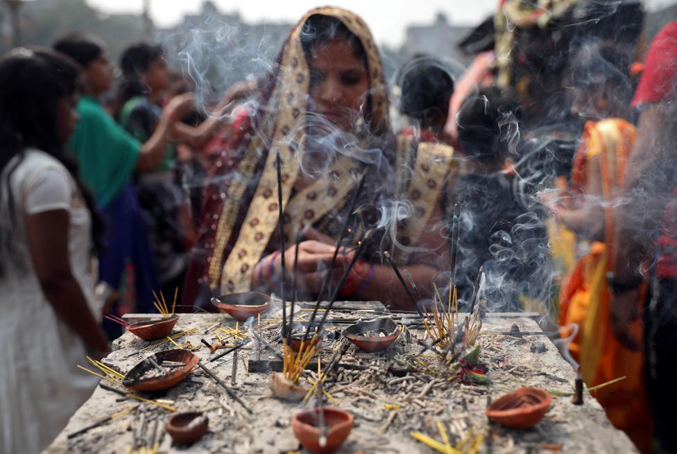 A woman burns incense sticks as she prays at a temple on the occasion of the Hindu festival of Maha Shivaratri in Kolkata, India, 21 February 2020.