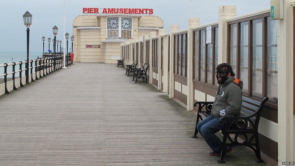 Aceves sitting on a bench on Worthing Pier