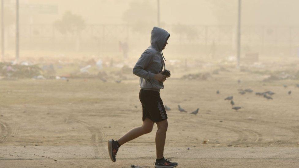 A person jogs near a ground despite the AQI being very poor to hazardous, on November 13, 2021 in Noida, India.