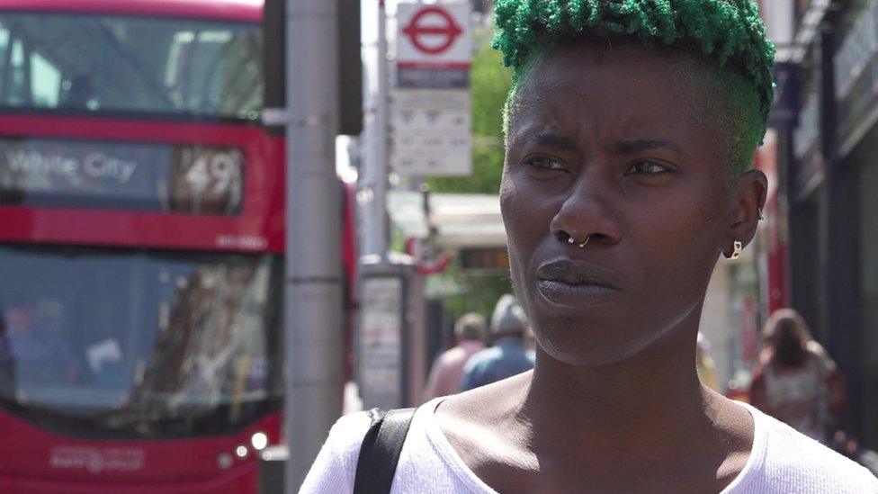 Sinead Hunter, a woman with short green hair, speaking on a busy street in Clapham Junction.