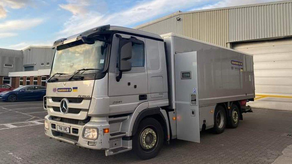 A silver Mercedes lorry parked