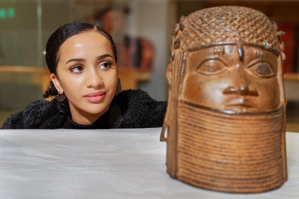 A woman looking at a bronze sculpture