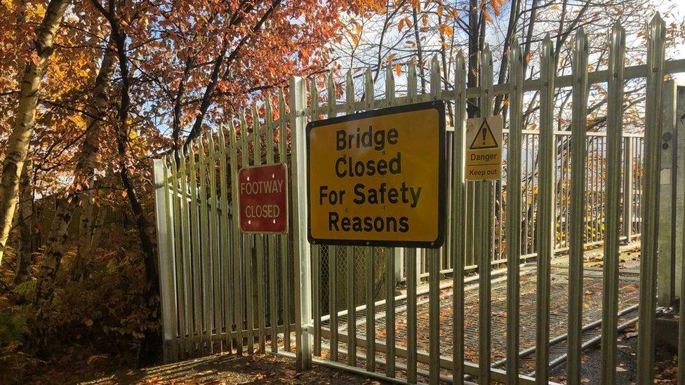 A sign on a gate that reads: bridge closed for safety concerns