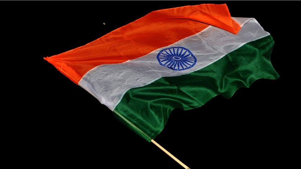 A supporter of Anti-corruption activist Anna Hazare waves the Indian national flag near the India Gate monument in New Delhi on August 28, 2011.