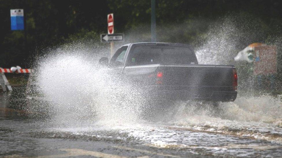 Car drives through floodwaters