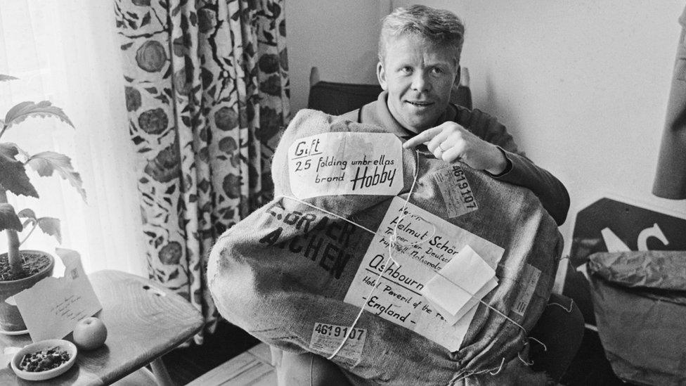 West German footballer Helmut Haller with a delivery of 25 folding umbrellas sent to the team at their Derbyshire hotel to help them cope with British weather, 14 July 1966. (Photo by Central Press/Hulton Archive/Getty Images)