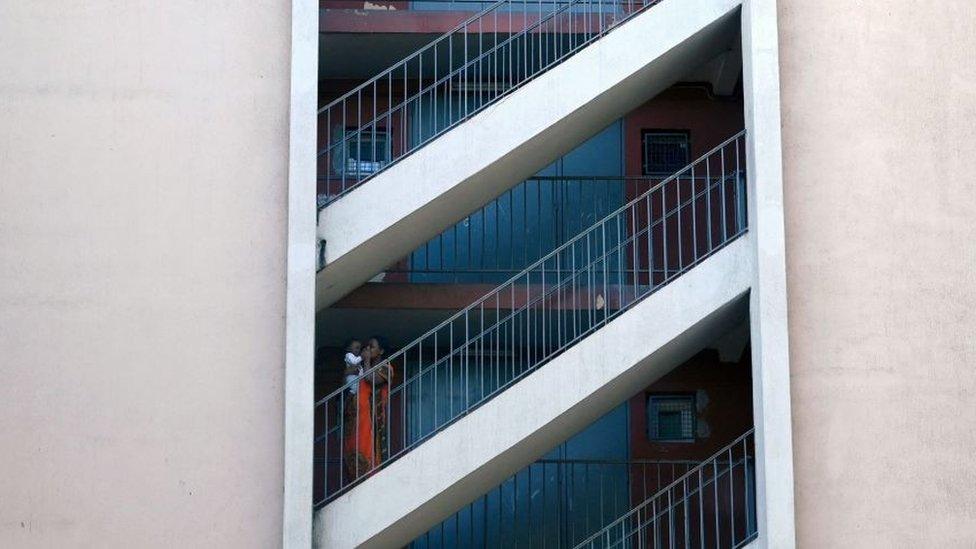 A woman and a child stand in a stairwell at "Les Rosiers" neighbourhood in Marseille