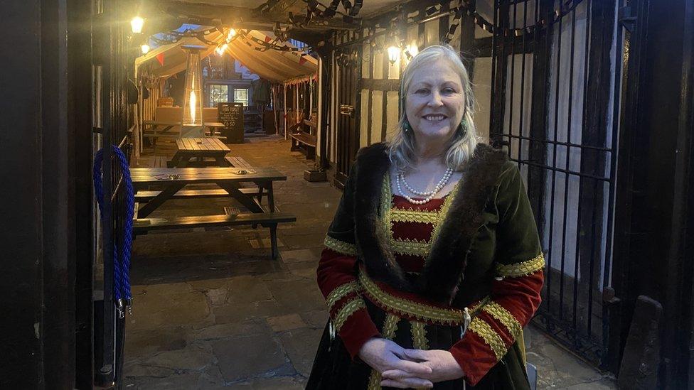 Woman with long light-coloured hair wearing a Tudor dress and shawl