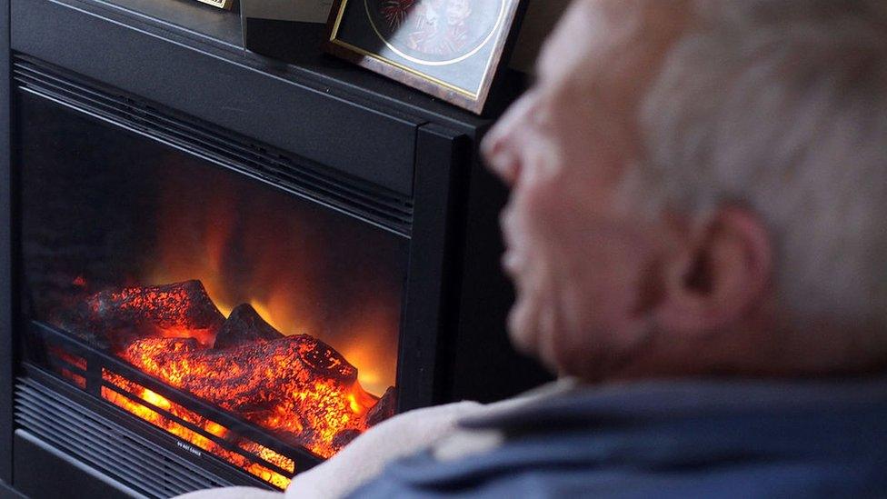 Elderly man in front of fire