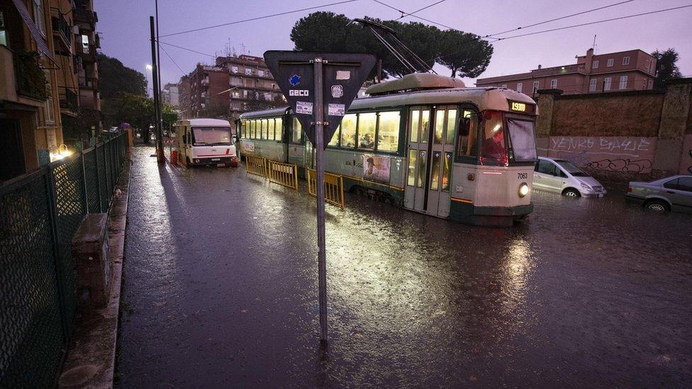 A tram drives in a flooded street due to heavy rain in Rome on 1 Nov