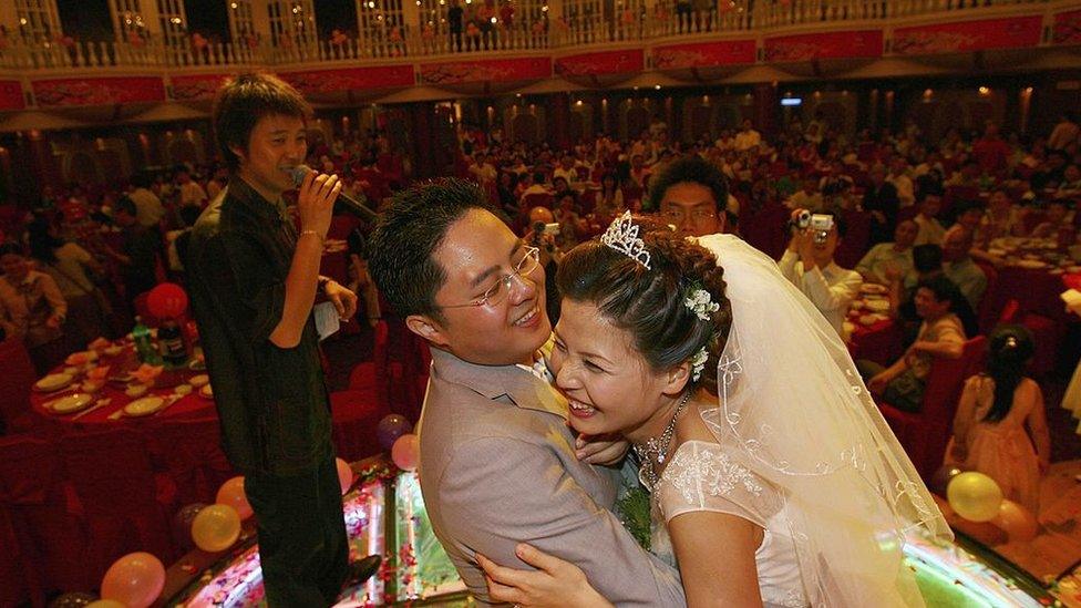 A couple hug during feast at a Chinese wedding ceremony