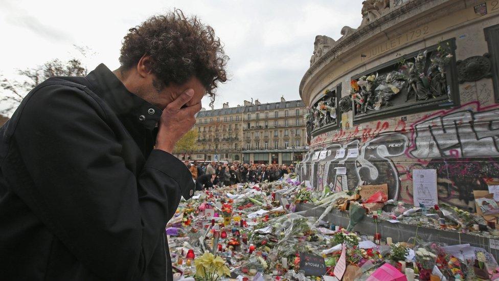 A man weeps for a lost friend as people gather to observe a minute-silence at the Place de la Republique in memory of the victims of the Paris terror attacks last Friday, on November 16, 2015 in Paris