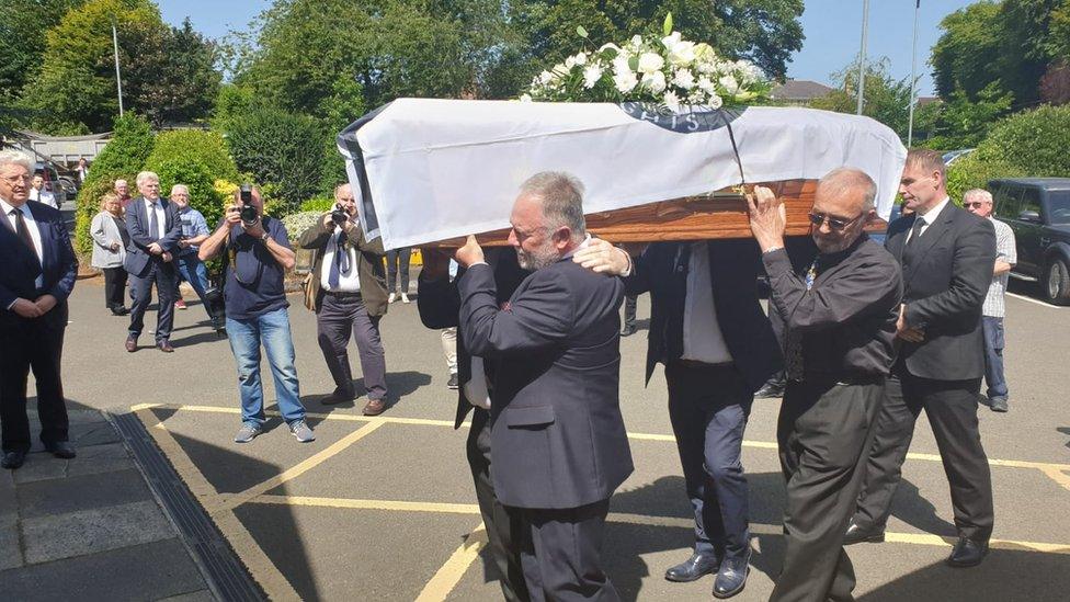 Men carry Ivan Cooper's coffin into St Peter's Church