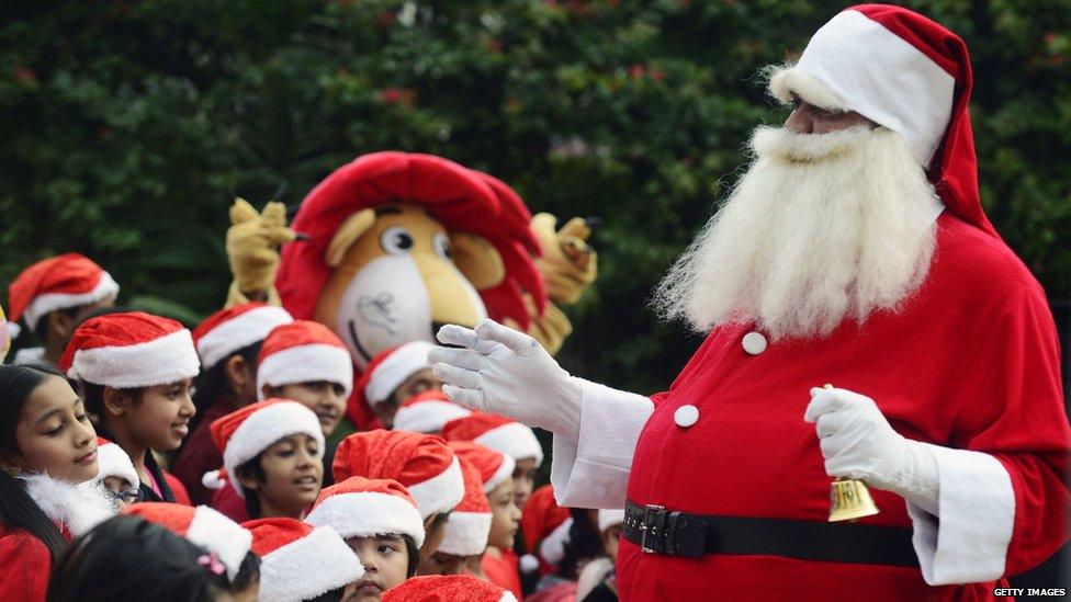 A Bangladeshi man dressed as Father Christmas entertains children during an event to mark Christmas Day in Dhaka on December 25, 2015