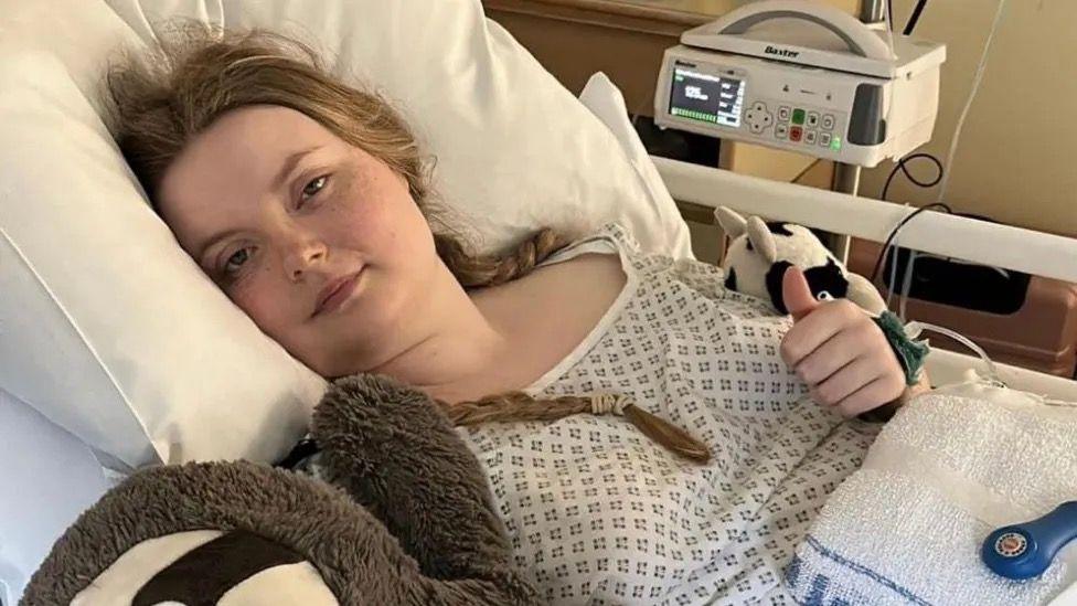 Abbie Kitson before in a hospital bed before surgery 